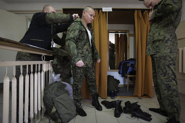 Conscript Piotr Piotrkowicz puts on his uniform for the first time. This year's class of drafted recruits is the final one after 90 years of compulsory military service, as Poland's army turns profess...
