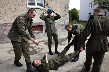 Young soldiers messing about during a cigarette break at the military base in Bartoszyce. This year's class of drafted recruits is the final one after 90 years of compulsory military service, as Polan...