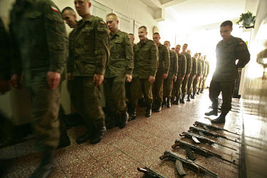 Soldiers gathering for early morning assembly, with AK-47 Kalashnikov rifles laid out on the floor. This year's class of drafted recruits is the final one after 90 years of compulsory military service...
