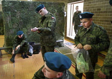 Young conscripts who have just arrived at the military base put on their new army uniforms. This year's class of drafted recruits is the final one after 90 years of compulsory military service, as Pol...