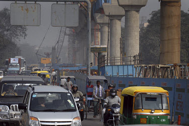 Traffic drives beside construction of an extension to Delhi's new Metro system, which the city is trying to complete before the start of the Commonwealth Games, to be staged in Delhi in 2010.