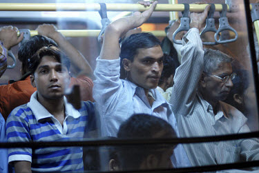 Passengers on a packed public bus at night in a traffic jam in central Delhi.