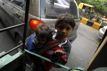 Street children begging in a traffic jam in affluent south Delhi.