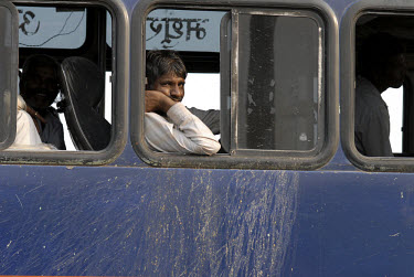 Man on a long distance bus (identifiable by the vomit stains under each window) stuck in a traffic jam in central Delhi.