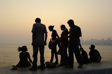 A group of middle class youths on Marine Drive waterfront at dusk.