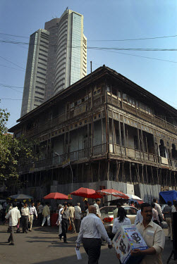 Traditional woodframe building sits in front of the tower of the Stock Exchange in central Mumbai.