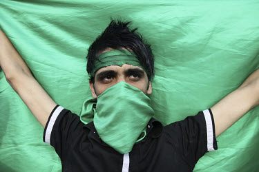 A young man wearing green, the colour of the opposition. An estimated one million people formed a human chain along Vali asr Avenue, the longest street in Tehran. Following a disputed election result,...