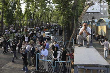 A man watches from atop a bus shelter as an estimated one million people form a human chain along Vali asr Avenue, the longest street in Tehran. Following a disputed election result, thousands of supp...