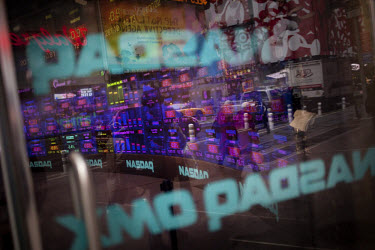 Share prices are displayed on a television set with the name NASDAQ, a technology heavy virtual stock exchange, in Times Square.