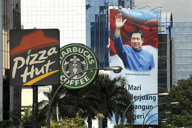 Poster supporting President Susilo Bambang Yudihoyono, vies with the signs of Western fastfood outlets, Pizza Hut and Starbucks Coffee, along one of central Jakarta's main thoroughfares.