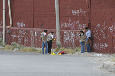 Police investigators and military police at a murder scene. Ciudad Juarez is the most violent city in Mexico, and the epicentre of the war on drugs. In 2008, 2,000 people were murdered, an average of...