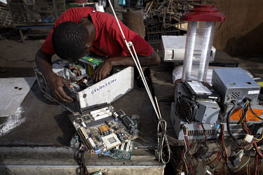 A man examines a hard drive at Agbogbloshie dump, which has become a dumping ground for computers and electronic waste from all over the developed world. Hundreds of tons of e-waste end up here every...