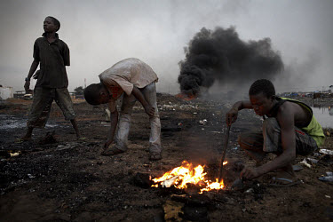 Children burn cables from computers and other electronic equipment in order to retrieve copper, at Agbogbloshie dump, which has become a dumping ground for computers and electronic waste from all over...