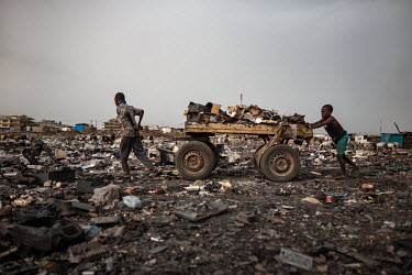 Children push a cart loaded with scrap, including computers keyboards and other e-waste, at Agbogbloshie dump, which has become a dumping ground for computers and electronic waste from all over the de...