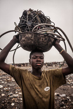 A boy carries electrical cables to a burning site at Agbogbloshie dump, which has become a dumping ground for computers and electronic waste from all over the developed world. Hundreds of tons of e-wa...