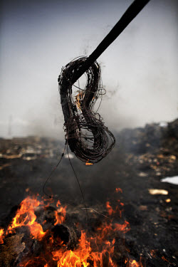 Burning cables from computers and other electronic equipment to retrieve copper, at Agbogbloshie dump, which has become a dumping ground for computers and electronic waste from all over the developed...