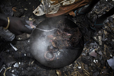 Children use water to cool down copper that has just been retrieved by burning, at Agbogbloshie dump, which has become a dumping ground for computers and electronic waste from all over the developed w...