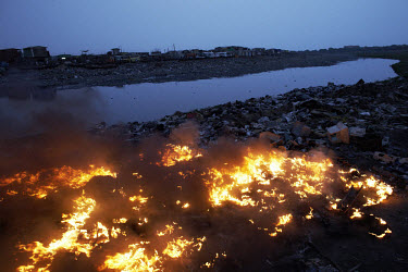 Monitor casings and other plastics burn along the edge of Agbogbloshie dump, which has become a dumping ground for computers and electronic waste from all over the developed world. Hundreds of tons of...