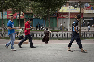 A Uighur woman carries a pole for protection in Urumqi. Ethnic violence between the Uighur and Han people had erupted in the city a few days earlier.