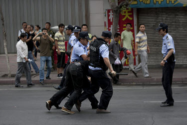 Police arrest a Han Chinese man who was part of a mob that chased down a Uighur in Urumqi. They caught up with the Uighur and beat him before the police intervened firing shots in the air and arrestin...