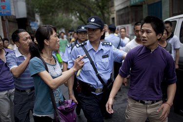 A policeman arrests a Han Chinese man who was part of a mob that chased down a Uighur in Urumqi. They caught up with the Uighur and beat him before the police intervened firing shots in the air and ar...