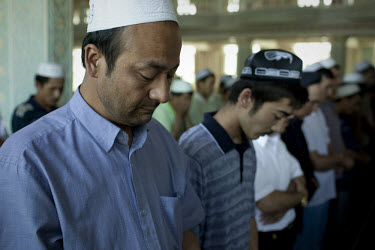 Uighur men pray at Yang Hang Mosque during Friday prayers in Urumqi. Due to the recent ethnic violence, Chinese authorities had tried to stop Friday prayers going ahead but at the last minute the door...