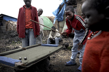 Displaced children play pool on a home made table in the Mugunga II IDP (Internally Displaced Persons) camp.