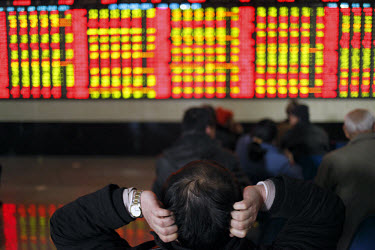 Investors watch and trade at one of the securities exchange house in Shanghai.