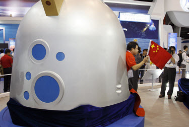 A Chinese TV presenter walks out of a model of the Shengzhou VII landing craft at the 2008 China International Aerospace and Aviation Exhibition in Zhuhai.