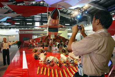 A man takes a picture of a model of Chinese made J-10 Interceptor at the 2008 China International Aerospace and Aviation Exhibition in Zhuhai.