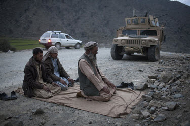 Men pray at the site of a roadside bomb next to a US Army Humvee near Naray village in Kunar. The HHT Unit of the 3rd Brigade Combat Team, 1st Infantry Division responded to an IED (improvised explosi...