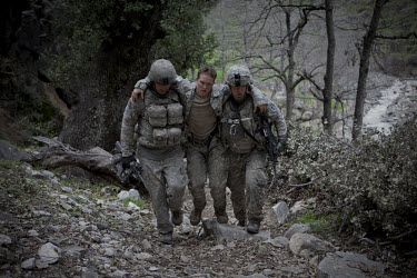 US Army soldiers from Viper Company 126, 2nd Platoon, help medevac Specialist Tenut who collapsed suffering from exhaustion during a mission in the restive Korengal Valley, epicentre of the war and sc...