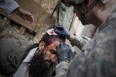 US Army Medic Sgt. Ester, Viper Company 126, 1st Platoon, treats Mohammed, a local driver from Korengal village who was shot in cross-fire at Restrepo Firebase in the restive Korengal Valley. Mohammed...