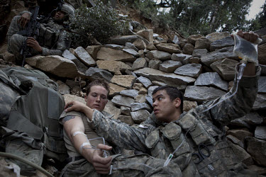 A US Army Medic treats Specialist Tenut from Viper Company 126, 2nd Platoon, who collapsed suffering from exhaustion during a mission in the restive Korengal Valley, epicentre of the war and scene of...