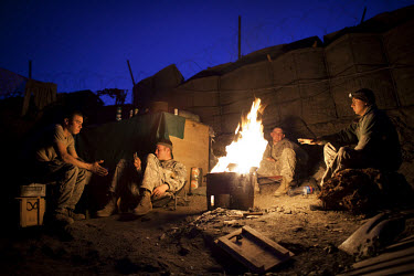 US Army soldiers from Viper Company 126, 1st Platoon, relax by a fire at Restrepo Firebase in the restive Korengal Valley close to the Pakistan border in Kunar. Restrepo, a remote outpost, is known as...