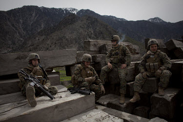 Marines rest in a lumber yard whilst on a mission in Nishigham village in Nuristan. They have recently disrupted the illegal logging trade that smuggles the wood across the border from Afghanistan cau...