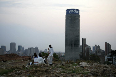 Worshippers belonging to a Zionist Christian church, conduct a sermon on a hilltop used as a place of worship near Yeoville in central Johannesburg. The Ponte Tower is in the background.