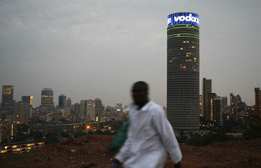 A man walks on a hilltop near Yeoville in central Johannesburg. The Ponte Tower is in the background.