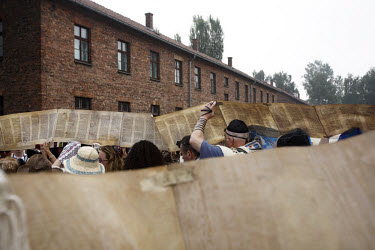 On a visit to the Auschwitz (Birkenau) former Nazi concentration camp organised by the Taube Foundation, Jewish cantors hold up an unwound Torah during the prayer for the dead. It is estimated that be...