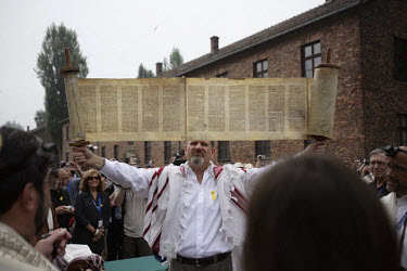 On a visit to the Auschwitz (Birkenau) former Nazi concentration camp organised by the Taube Foundation, one of a group of Jewish cantors holds up an unwound Torah during the prayer for the dead. It i...