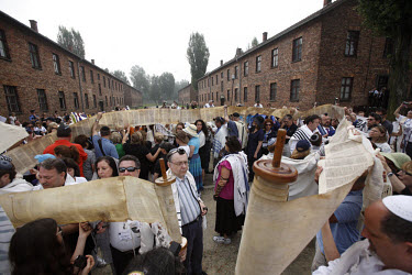 On a visit to the Auschwitz (Birkenau) former Nazi concentration camp organised by the Taube Foundation, Jewish cantors hold up an unwound Torah during the prayer for the dead. It is estimated that be...