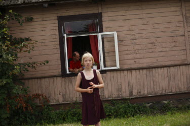 A girl watching the Tour De Pologne bicycle race from outside her home in Malkinia County.