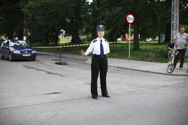 A policewoman stands by as people watch the Tour De Pologne bicycle race.