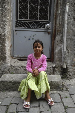 A young girl sits outside her family home in a working class neighbourhood of Trabzon.
