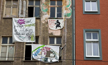 Banners hang from a building in East Berlin where squatters are resisting eviction. One banner reads ^We don't need your ugly Yuppie Flats. We are happy with our Rats.^ Another banner says ^To Destroy...