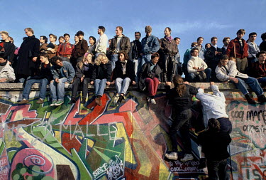 People climb onto the Berlin Wall on November 10th, 1989, the morning after the announcement by the East German government that they would start granting exit visas to East Germans wanting to go to th...