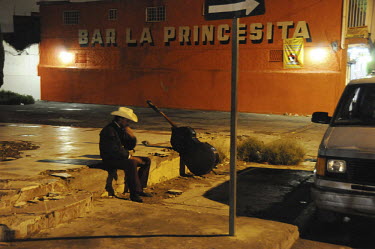 A member of a mariachi band waits on the roadside for work in the poor neighbourhood of Las Delicias.