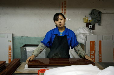Worker in packing department of Hong Qi wood floor factory, a private firm which produces floor boards for the booming domestic market and for export around the world, using imported wood.