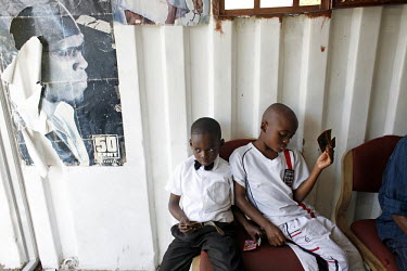 Nashir Nifasha (wearing an England football shirt) sits with a friend in a barber shop in Kensington, Cape Town. Both boys are originally from Burundi. Nashir's father Richard, a refugee from Burundi,...