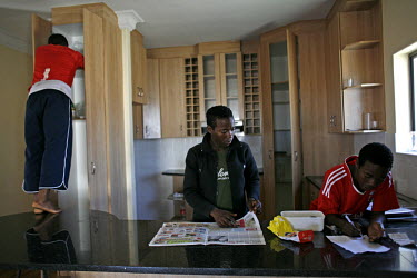 One of the Super Eaglets players searches the bare cupboards for food at the club's camp for players. Khayalethu and Khaya Nyati, 16 year old twins from Cape Town, are in the foreground. The Super Eag...